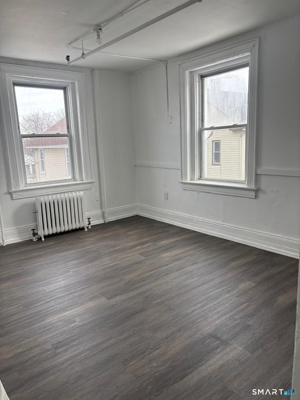 86 Pequonnock Street, Unit 20 Bridgeport, CT 06604 - Photo 2 of 5 an empty room with wooden floor and windows