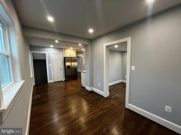an empty room with wooden floor and entrance