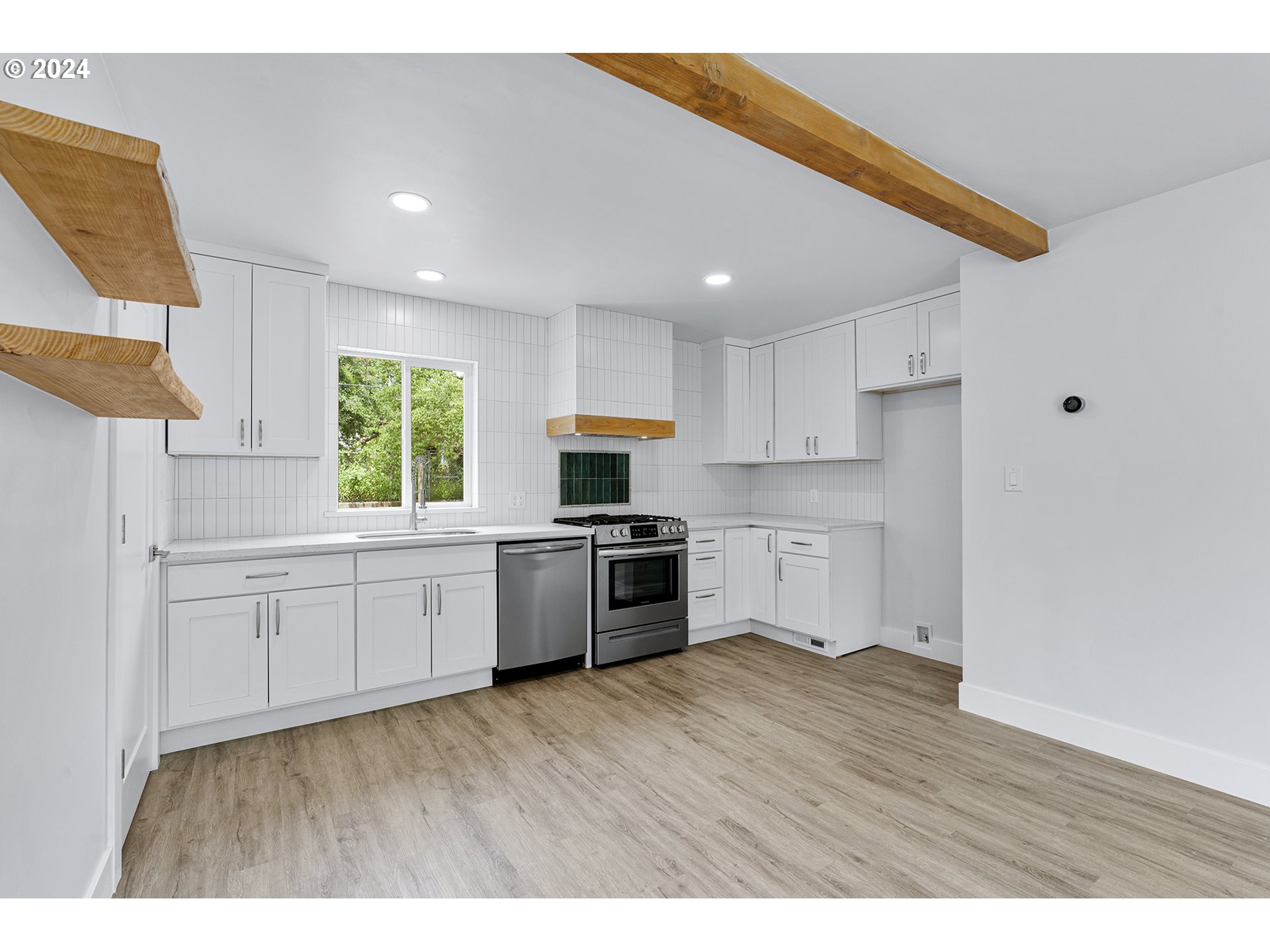 9045 Southeast Morrison Street Portland, OR 97216 - Photo 11 of 35 a kitchen with stove cabinets and wooden floor