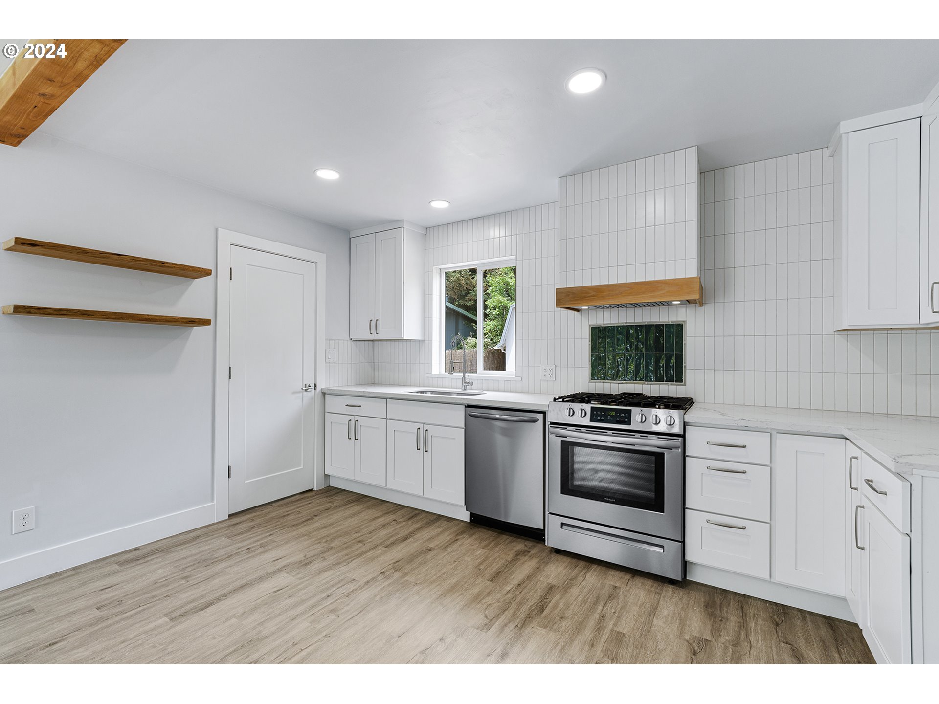 9045 Southeast Morrison Street Portland, OR 97216 - Photo 12 of 35 a kitchen with a stove a sink and a refrigerator