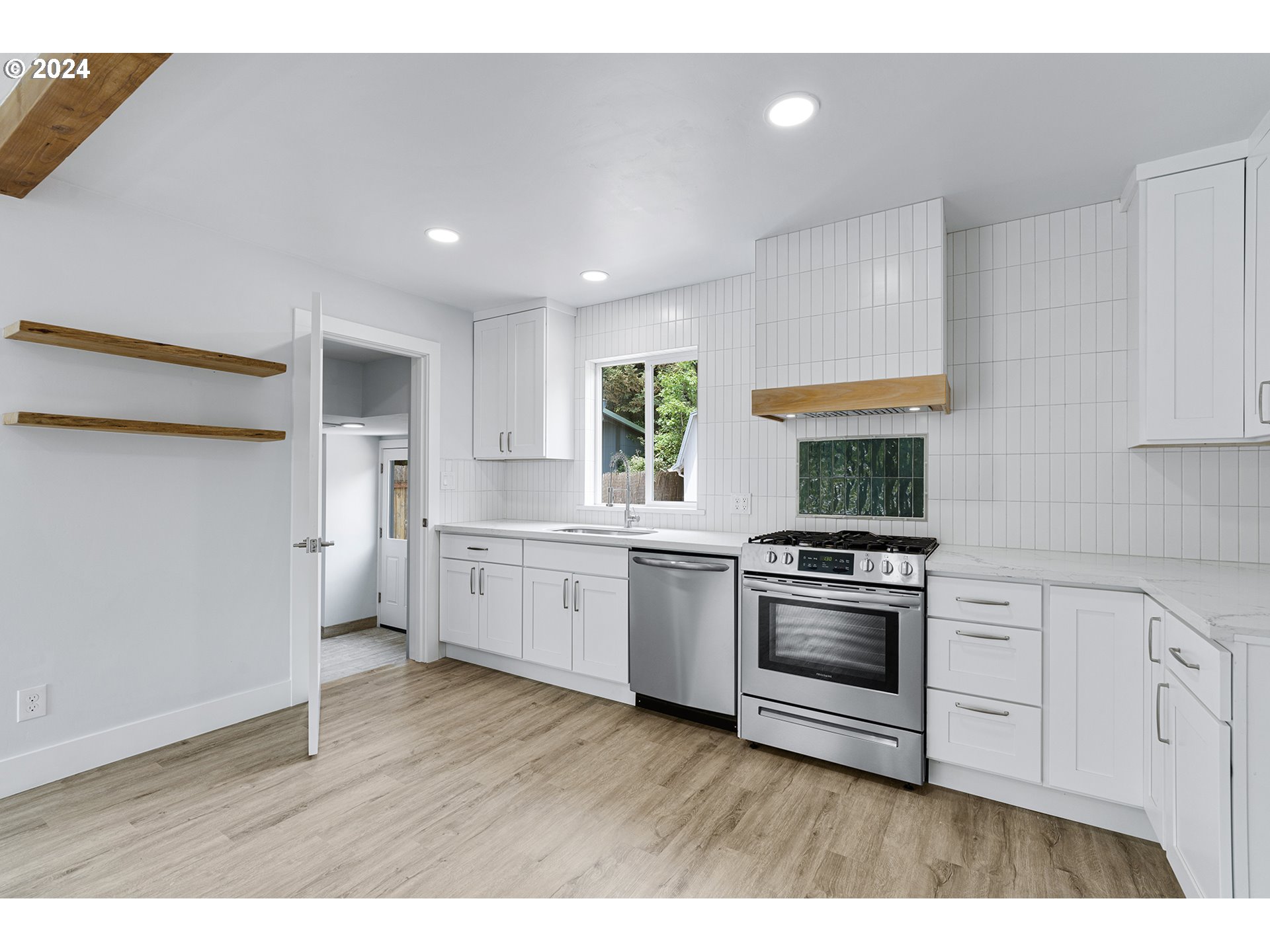 9045 Southeast Morrison Street Portland, OR 97216 - Photo 13 of 35 a kitchen with a stove a sink and a refrigerator