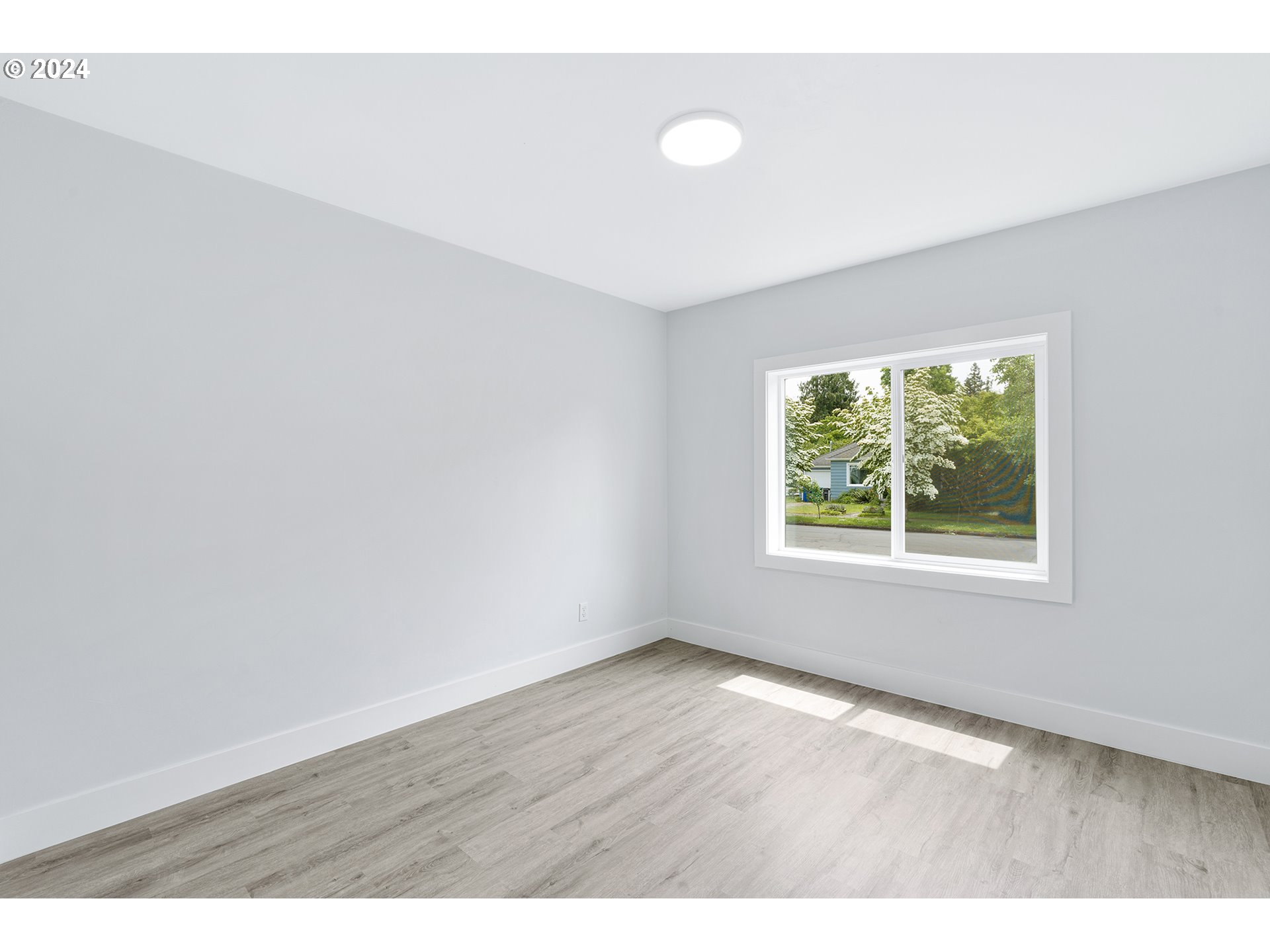 9045 Southeast Morrison Street Portland, OR 97216 - Photo 15 of 35 a view of an empty room with wooden floor and a window
