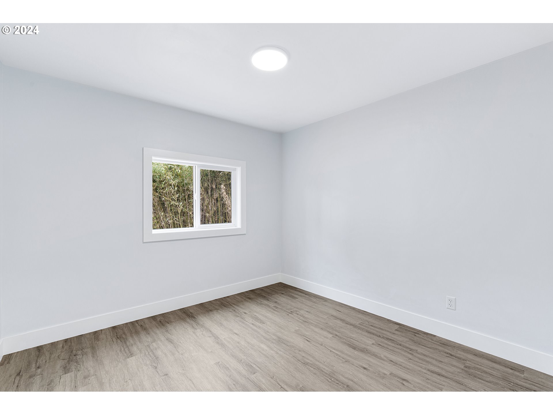 9045 Southeast Morrison Street Portland, OR 97216 - Photo 19 of 35 a view of an empty room with wooden floor and a window