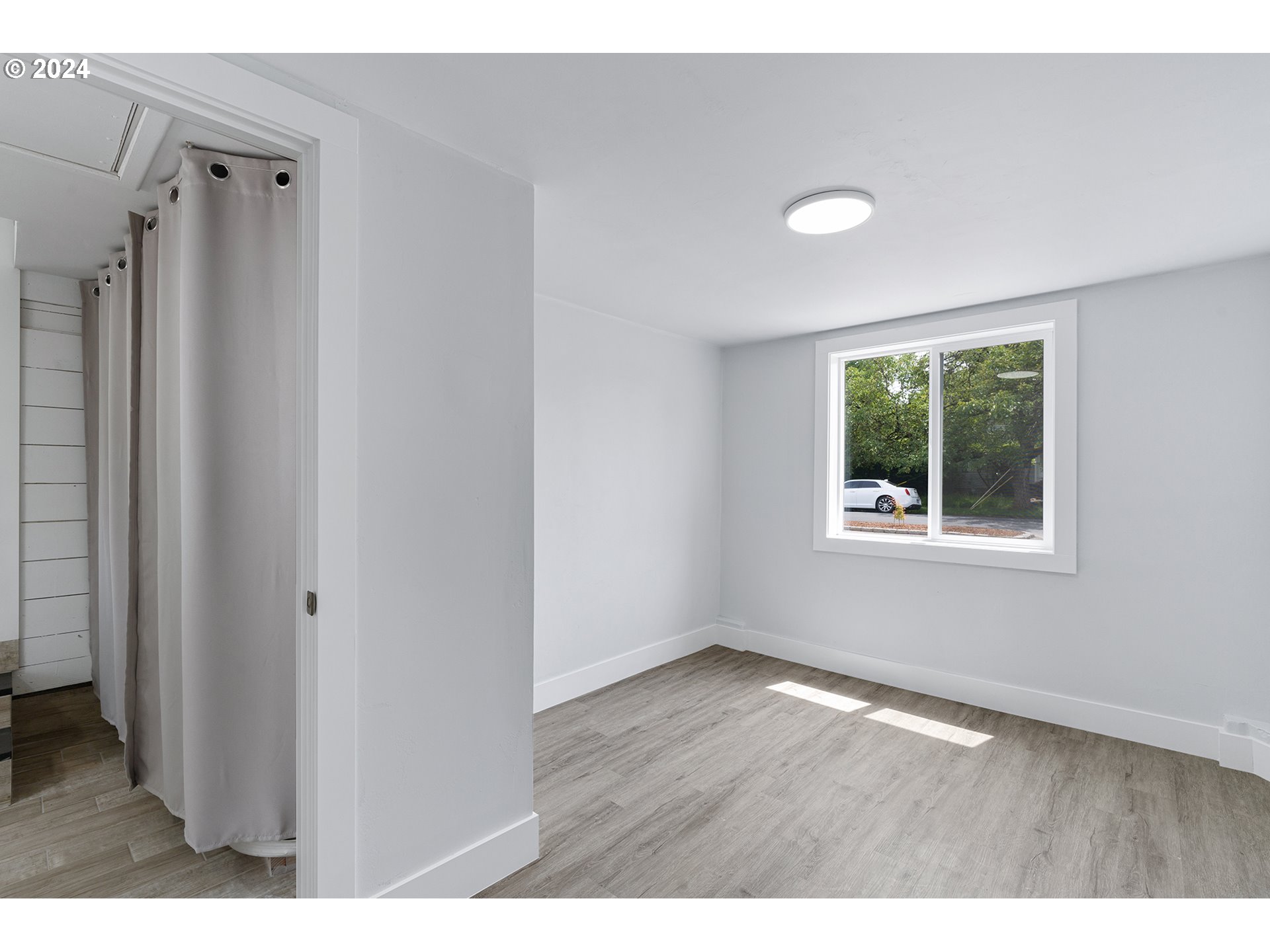 9045 Southeast Morrison Street Portland, OR 97216 - Photo 25 of 35 a view of an empty room with wooden floor and a window