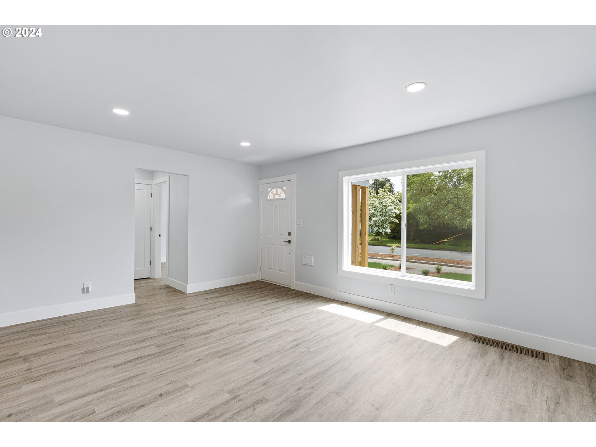 9045 Southeast Morrison Street Portland, OR 97216 - Photo 7 of 35 a view of an empty room with wooden floor and a window