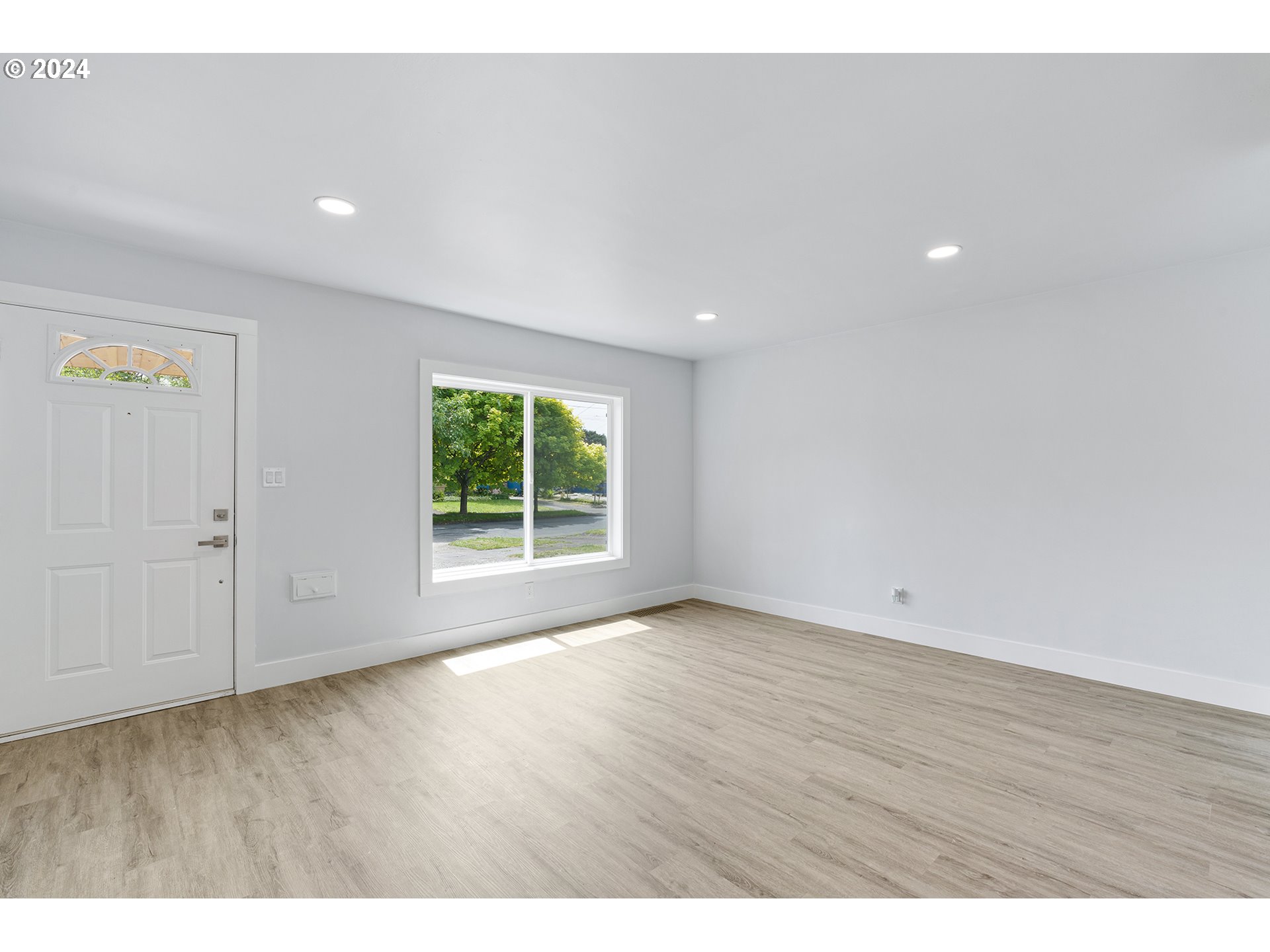 9045 Southeast Morrison Street Portland, OR 97216 - Photo 8 of 35 a view of an empty room with wooden floor and a window