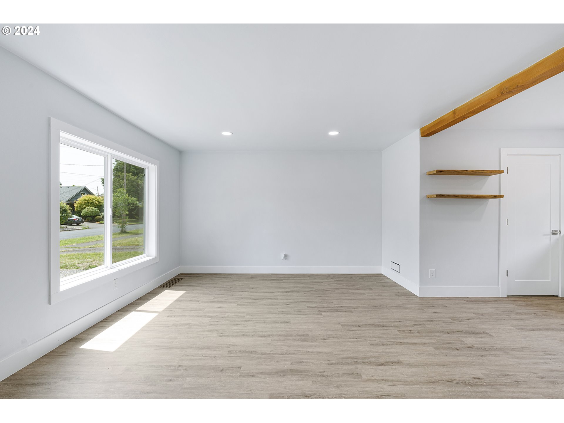 9045 Southeast Morrison Street Portland, OR 97216 - Photo 9 of 35 a view of an empty room with wooden floor and a window