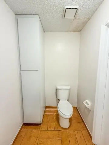 a view of a hallway with wooden floor and a living room