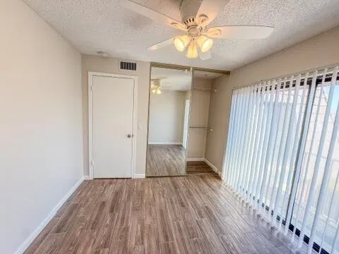 a view of a hallway with wooden floor and closet