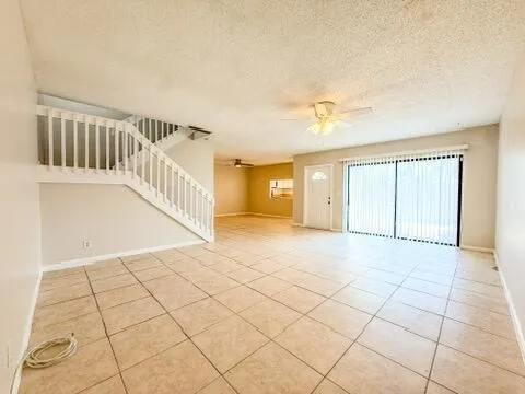 a view of an empty room and a kitchen