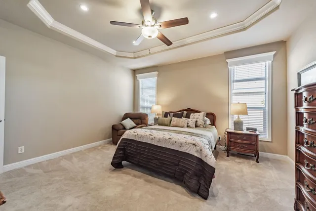 a spacious bedroom with a bed and a ceiling fan