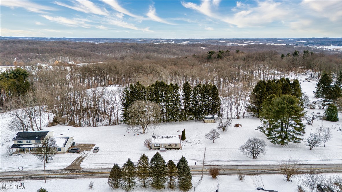 6160 Dresden Road Zanesville, OH 43701 - Photo 32 of 32 Snowy aerial view featuring a wooded view