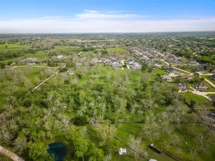 an aerial view of residential houses with outdoor space and trees