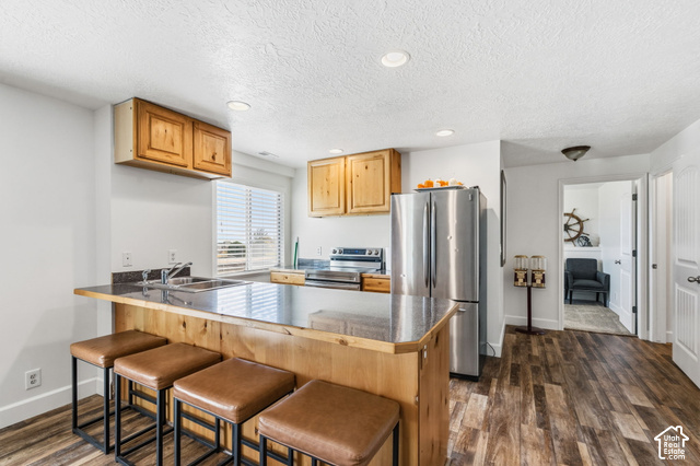 9044 North Cedar Pass Road Eagle Mountain, UT 84005 - Photo 33 of 63 Wood-finish flooring throughout, stainless steel appliances, wood cabinetry, built-in breakfast bar, and recessed lighting