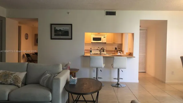 a living room with a couch and a view of kitchen