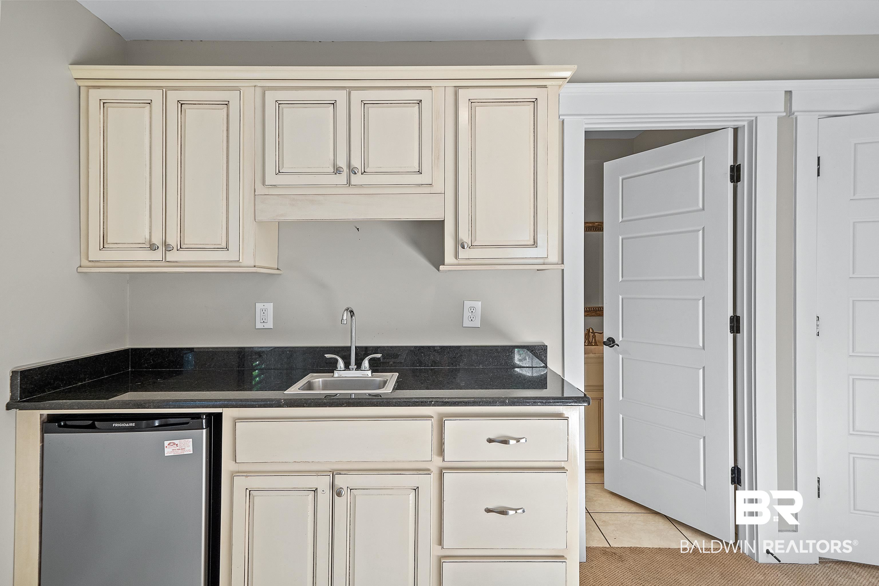356 Liberty Street Fairhope, AL 36532 - Photo 27 of 39 Kitchen with dishwasher, cream cabinets, dark countertops, and light tile patterned flooring