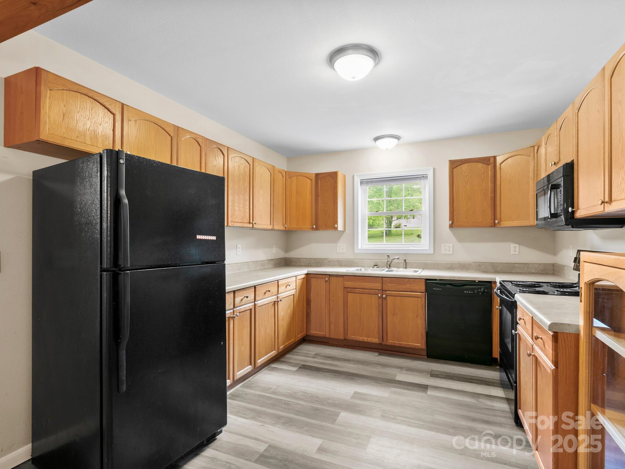 186 Wiggins Road Candler, NC 28715 - Photo 15 of 32 a kitchen with stainless steel appliances granite countertop a refrigerator a stove a sink and a microwave