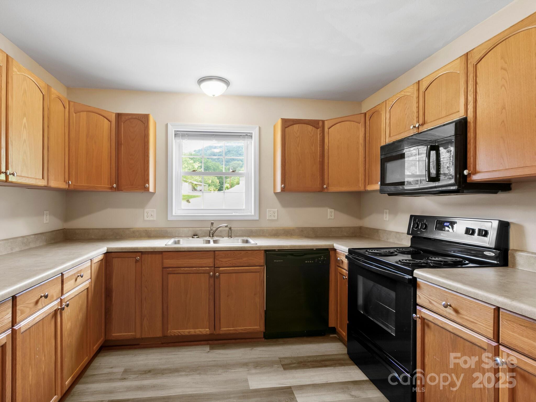 186 Wiggins Road Candler, NC 28715 - Photo 16 of 32 a kitchen with stainless steel appliances granite countertop a sink stove and microwave