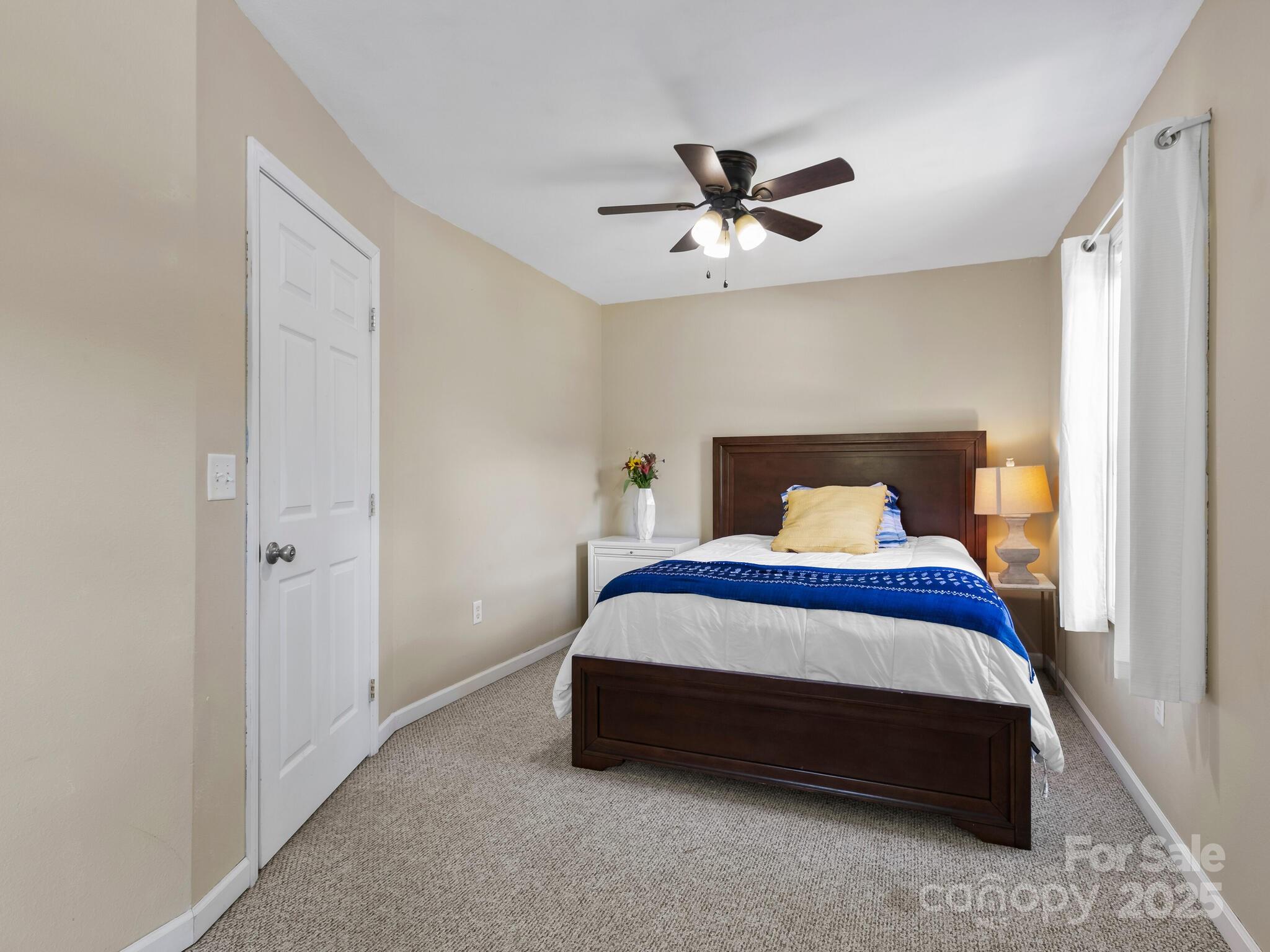 186 Wiggins Road Candler, NC 28715 - Photo 20 of 32 a bedroom with a bed and a chandelier