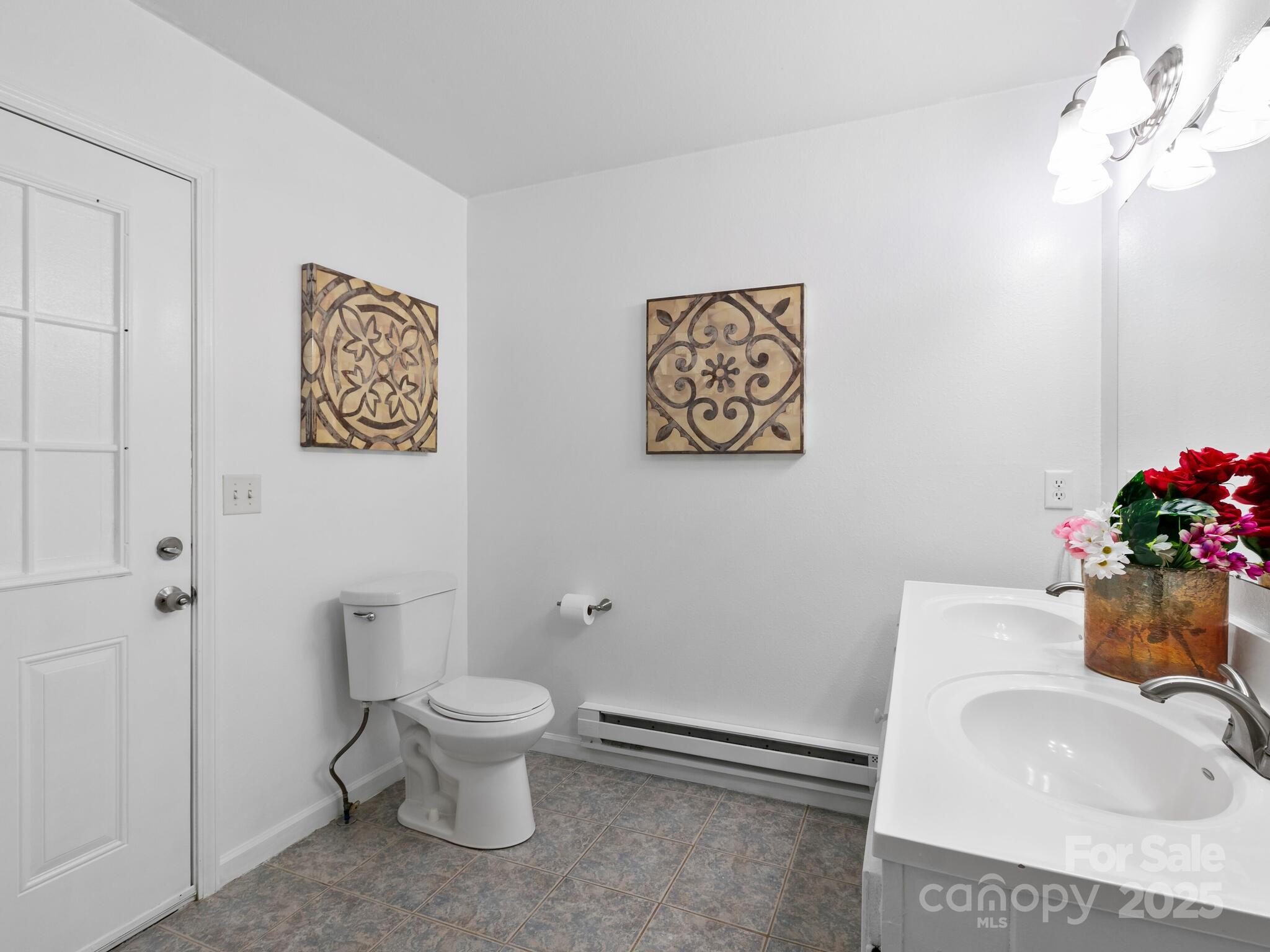 186 Wiggins Road Candler, NC 28715 - Photo 23 of 32 a bathroom with a toilet sink and mirror