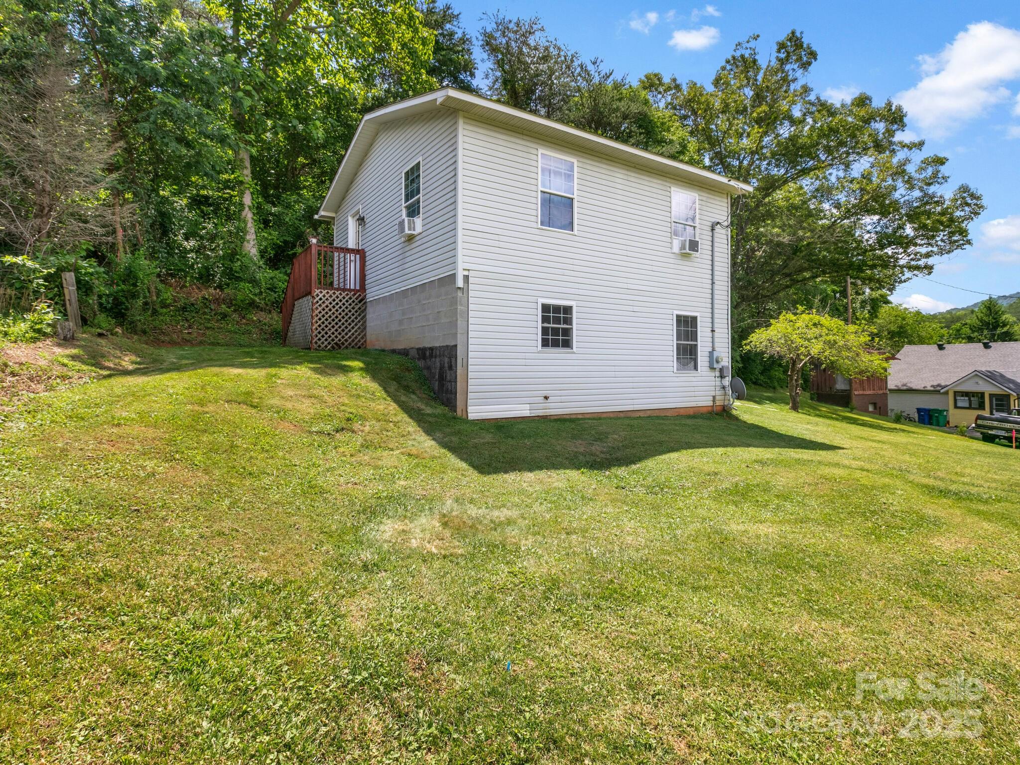 186 Wiggins Road Candler, NC 28715 - Photo 29 of 32 a view of a backyard with plants and large tree