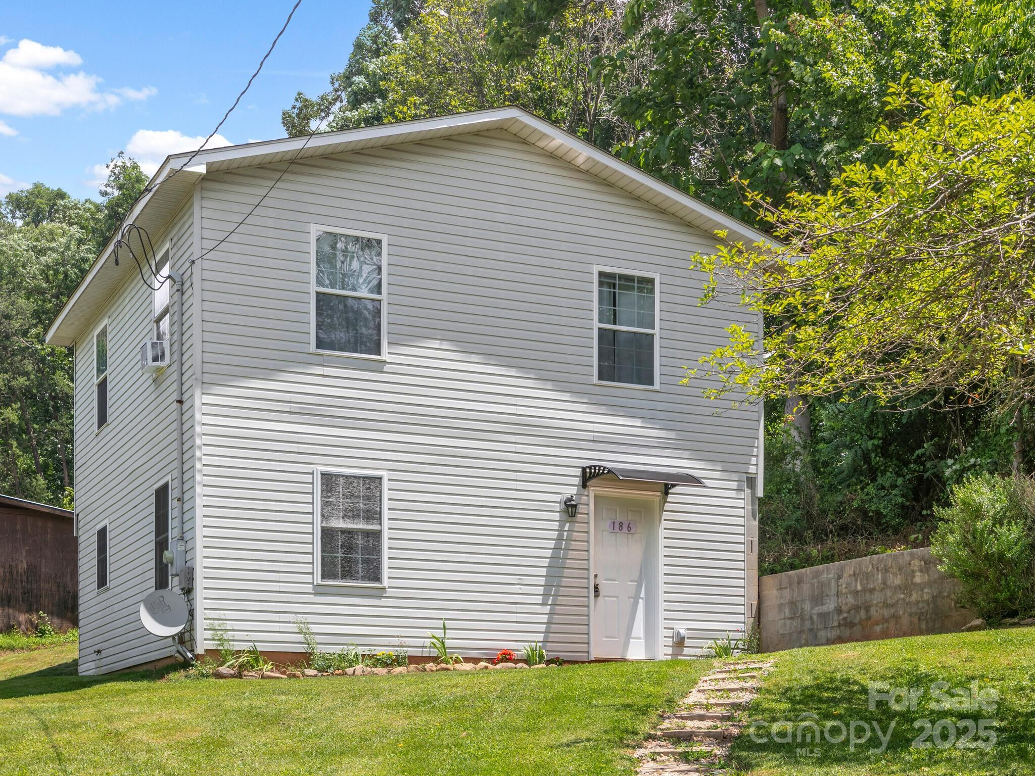 186 Wiggins Road Candler, NC 28715 - Photo 3 of 32 a front view of a house with a yard