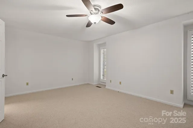 an empty room with chandelier fan