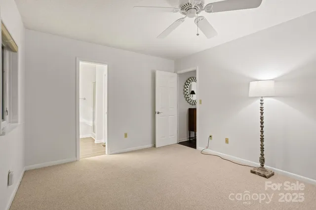 a view of an empty room with chandelier fan