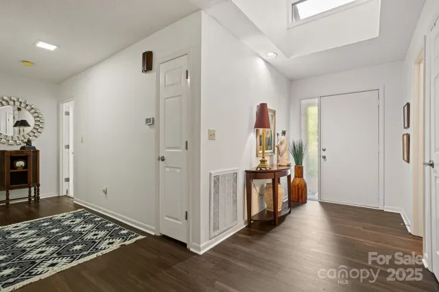 a view of a hallway with wooden floor and windows