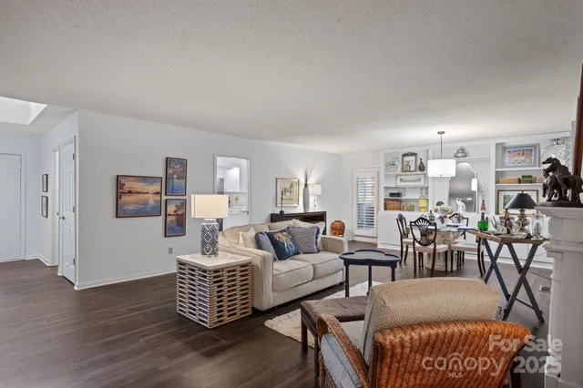 a living room with furniture a lamp and wooden floor