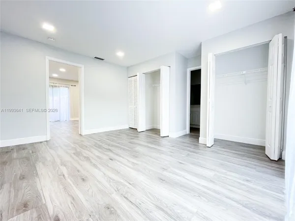 a view of empty room with wooden floor