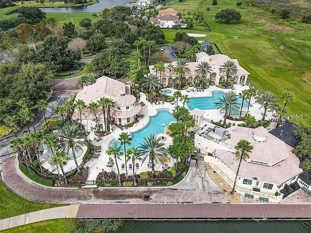 an aerial view of a house with a yard and lake
