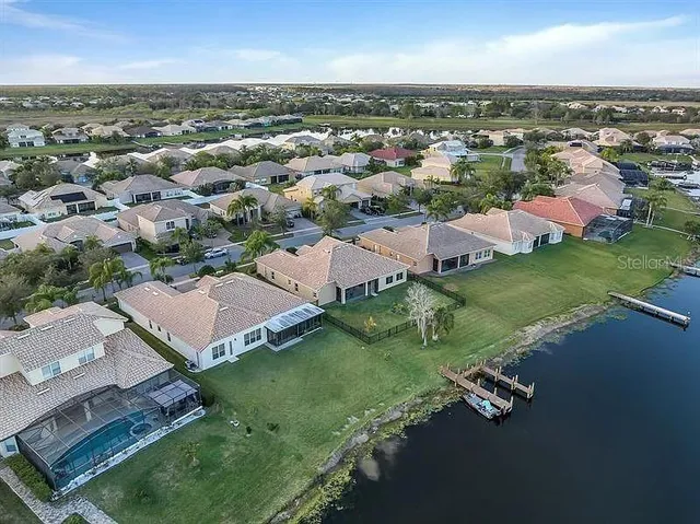 an aerial view of residential houses with outdoor space and trees