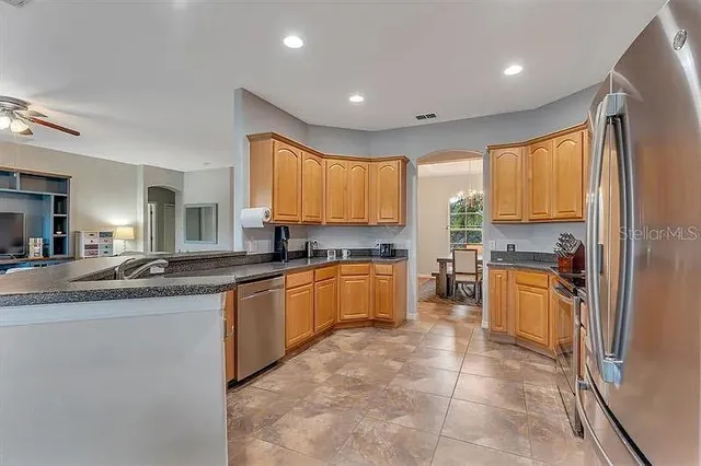a large kitchen with a large counter top sink and stainless steel appliances