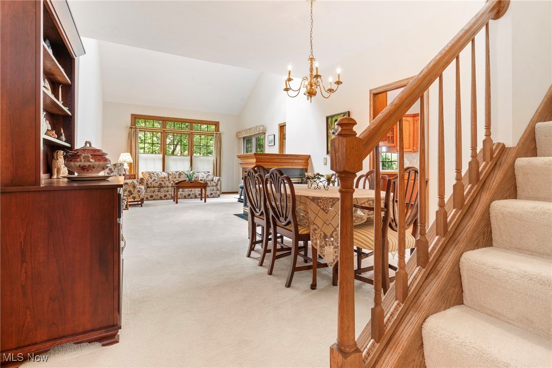 2503 Charing Cross Road Northwest Canton, OH 44708 - Photo 14 of 30 Dining room featuring high vaulted ceiling, light carpet, and a notable chandelier