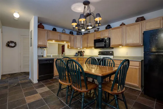 a kitchen with granite countertop a dining table and chairs