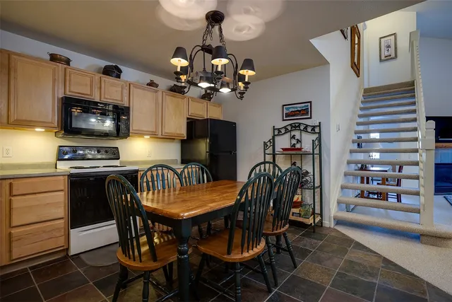 a kitchen with granite countertop a table chairs microwave and cabinets