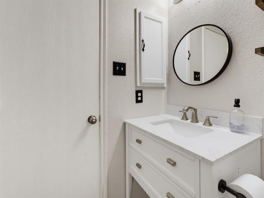 600 Stirling Road Rhome, TX 76078 - Photo 22 of 38 White vanity with a single basin sink and a stone-finish countertop
