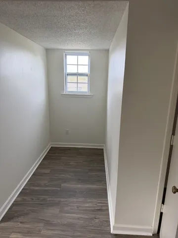 an empty room with wooden floor and window