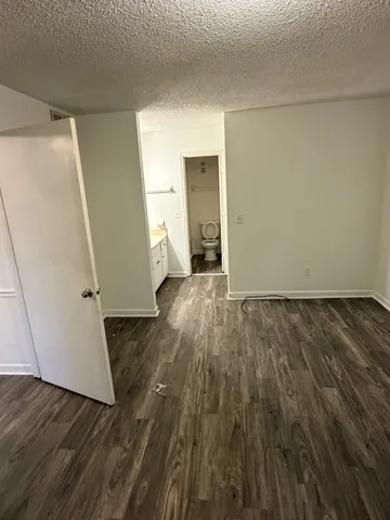 an empty room with wooden floor and entrance