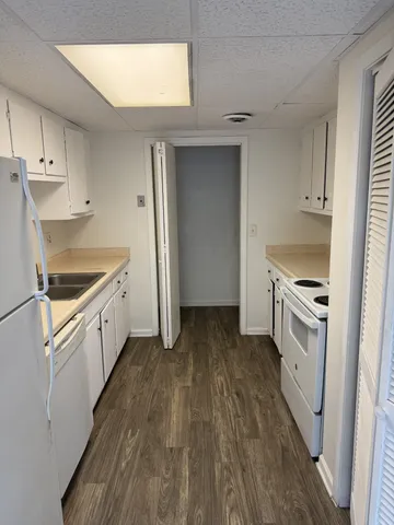 a kitchen with granite countertop white cabinets and white appliances