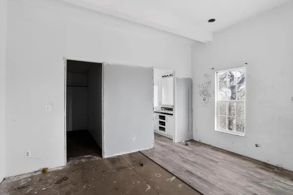 an empty room with a window and a fan