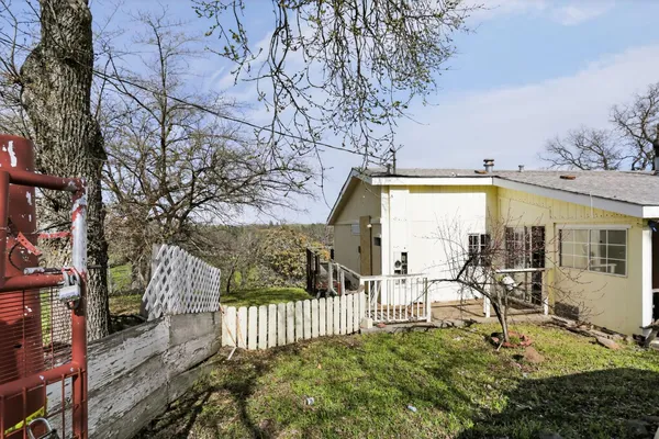 a view of a porch with a bench and wooden fence