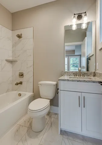 a bathroom with a granite countertop toilet sink and a mirror