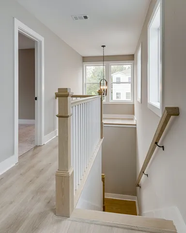 a view of a hallway with wooden floor and staircase
