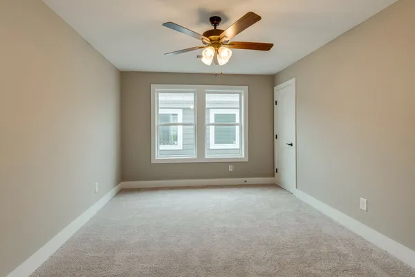 an empty room with a window and a ceiling fan
