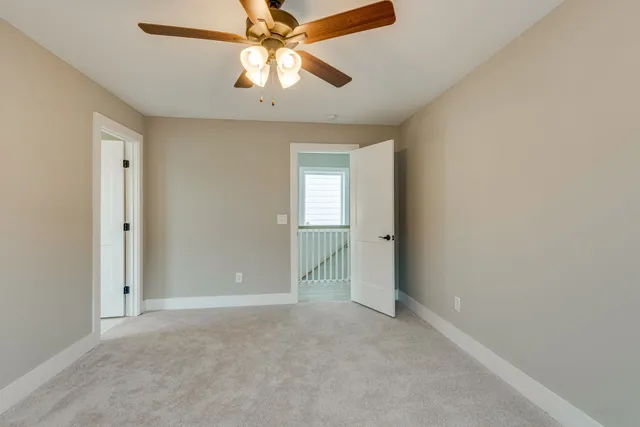 an empty room with closet and a chandelier fan