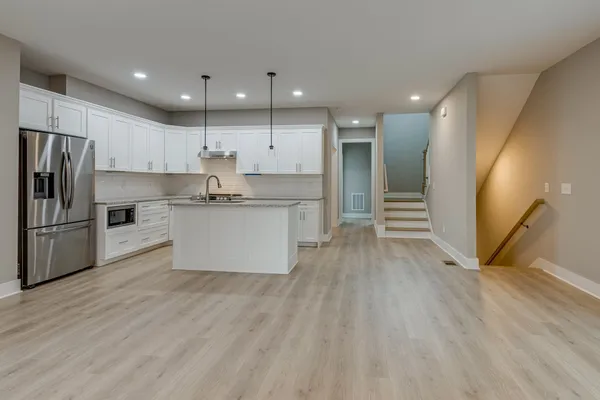 a kitchen with stainless steel appliances a refrigerator sink and cabinets