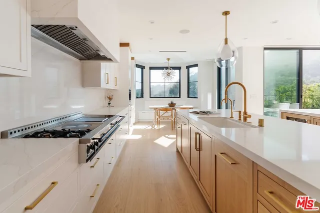 a kitchen with stainless steel appliances a sink stove and cabinets