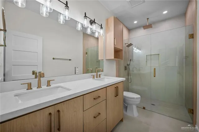 a bathroom with a double vanity sink toilet and shower